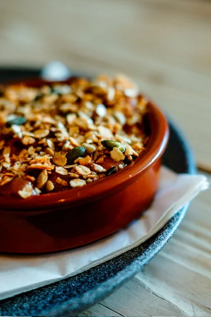 A baked dish in a terracotta bowl at Guys Bar