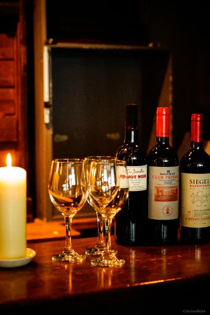 Wine bottles and glasses beside candlelight at Guys Bar